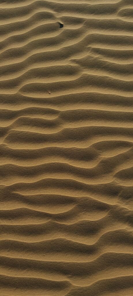A captivating aerial view of wavy sand dunes showcasing natural desert patterns.