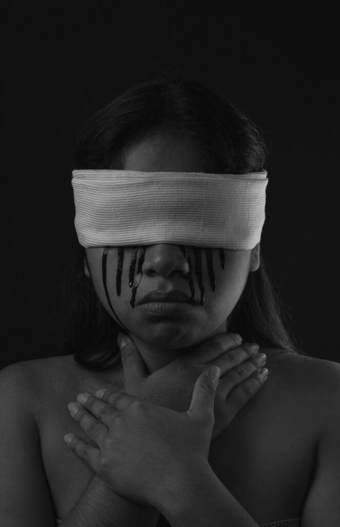 A dramatic grayscale portrait of a blindfolded woman expressing silence and introspection.