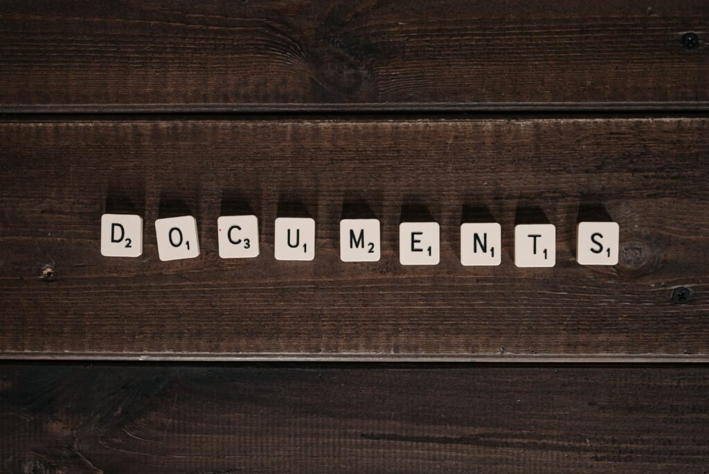 "La nueva escena del crimen documental" Scrabble tiles spelling 'Documents' arranged on a dark wooden background, conveying concepts of writing and organization.