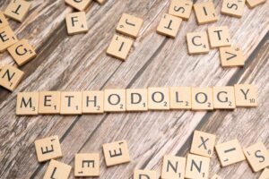 Inicio Wooden letter tiles spelling 'methodology' on a textured wooden surface, emphasizing research.