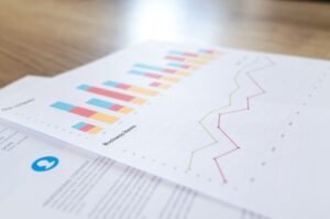 Inicio A close-up view of a business document with charts and graphs on a wooden desk.
